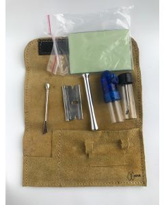 A leather tool kit featuring a knife, scissors, and various tools, designed for portability and discreet travel use.